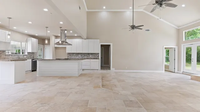 an empty room with windows and fireplace