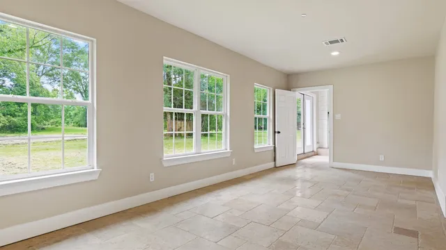 an empty room with a window and a fan