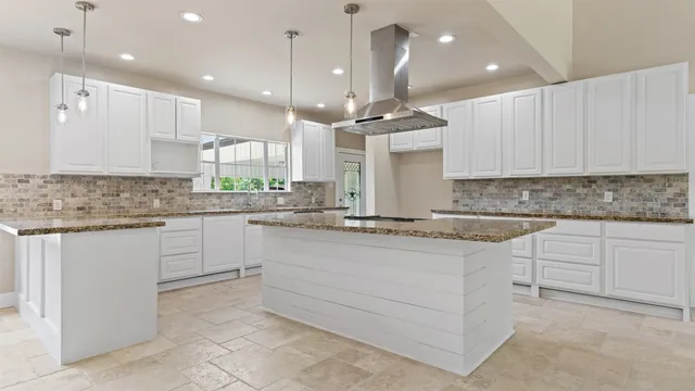 a kitchen with kitchen island granite countertop a counter space windows and a fireplace