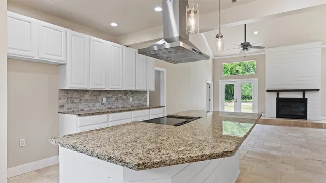 a kitchen with a stove a faucet a chandelier and living room view