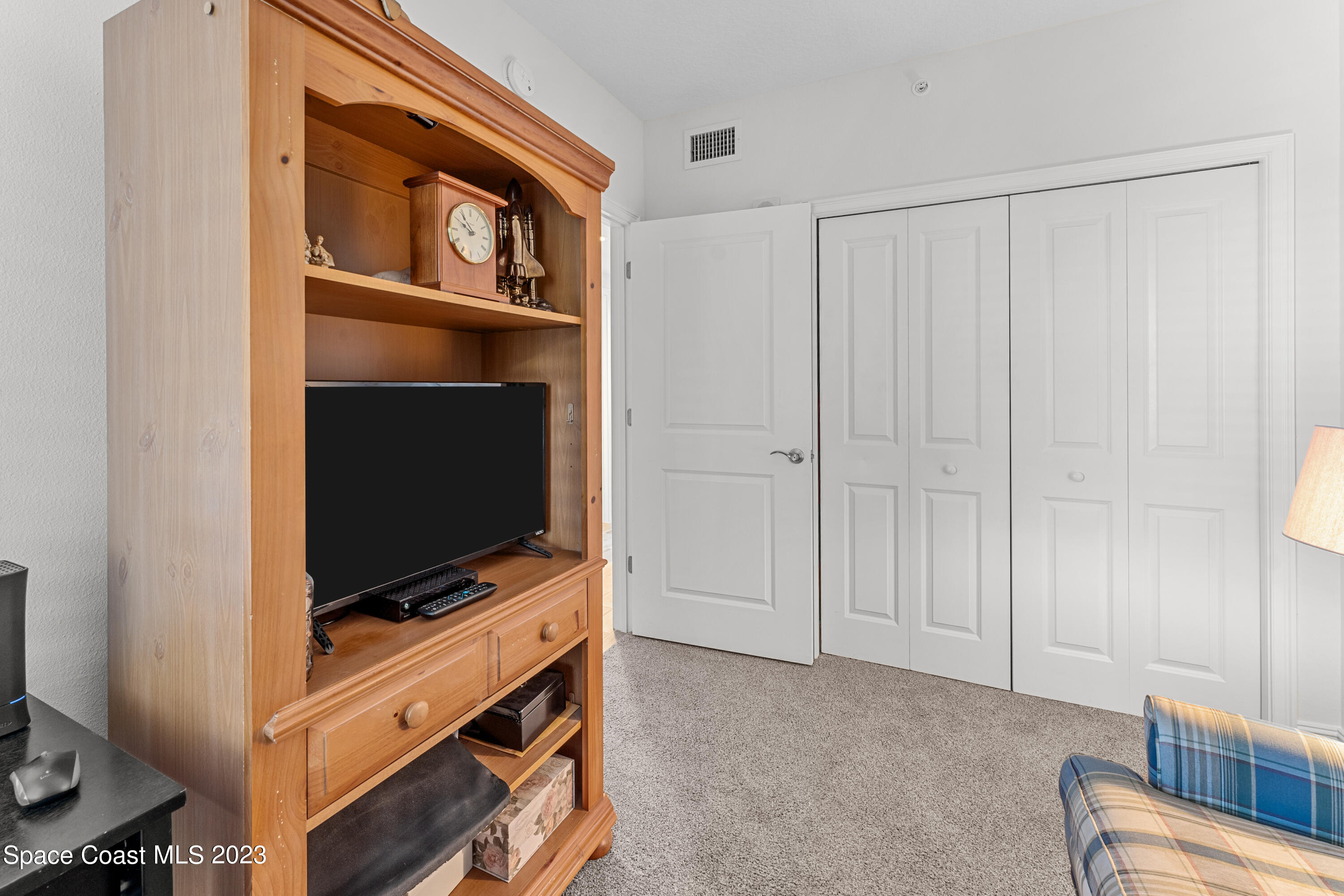 1825 Riverside Drive, Unit 305S Titusville, FL 32780 - Photo 12 of 34 a room with furniture and flat screen tv