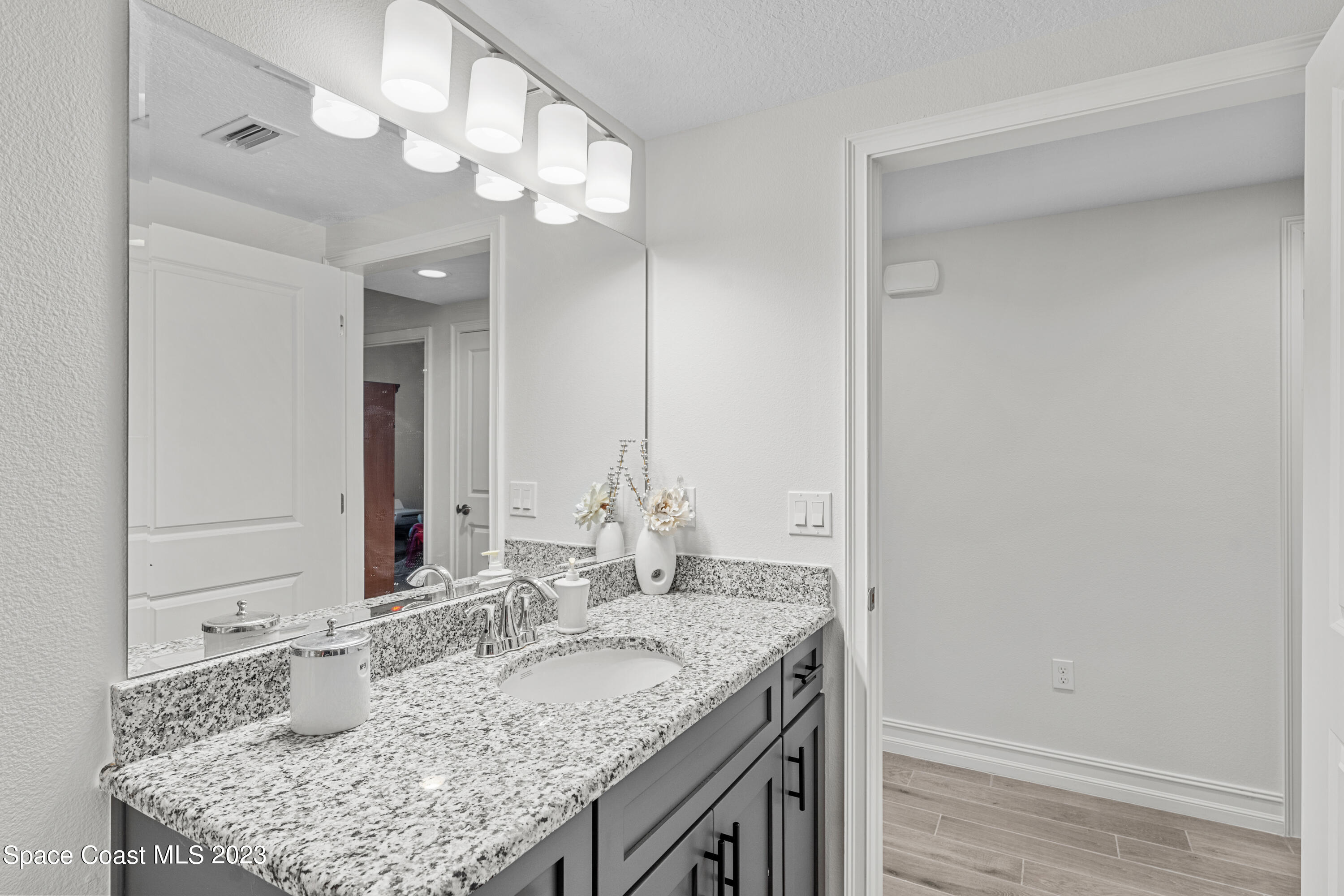 1825 Riverside Drive, Unit 305S Titusville, FL 32780 - Photo 15 of 34 a bathroom with a granite countertop sink and a mirror