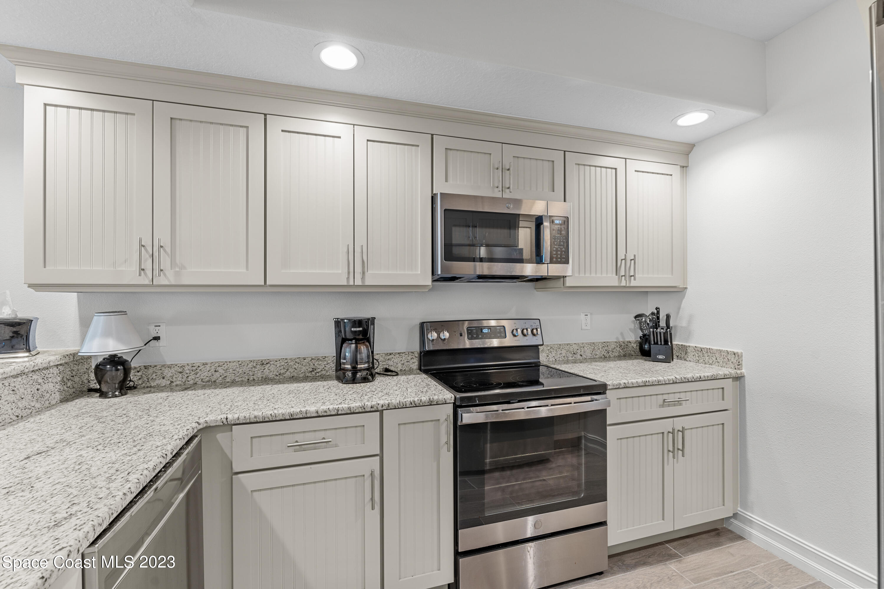 1825 Riverside Drive, Unit 305S Titusville, FL 32780 - Photo 17 of 34 a kitchen with white cabinets stainless steel appliances and sink