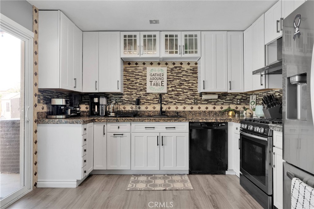 14111 Liberty Way Victorville, CA 92392 - Photo 14 of 39 a kitchen with stainless steel appliances granite countertop a stove a sink and white cabinets