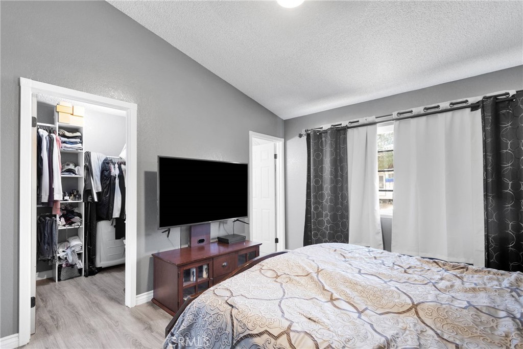 14111 Liberty Way Victorville, CA 92392 - Photo 19 of 39 a bedroom with a bed and a flat tv screen on wall