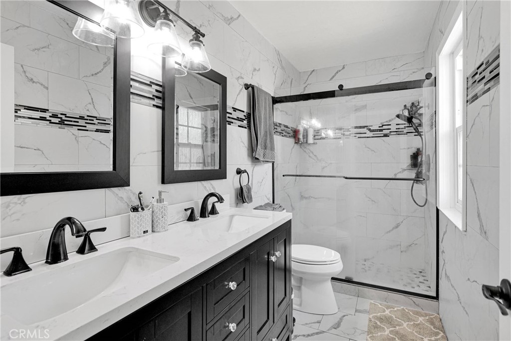 14111 Liberty Way Victorville, CA 92392 - Photo 20 of 39 a bathroom with a double vanity sink toilet and shower