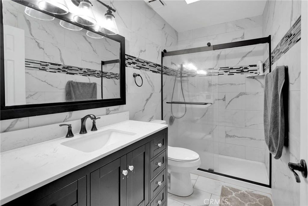 14111 Liberty Way Victorville, CA 92392 - Photo 24 of 39 a bathroom with a double vanity sink mirror double shower and a toilet