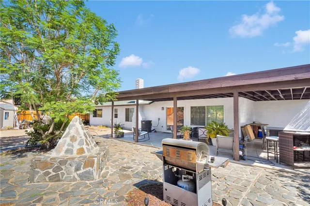 a patio with a table and chairs under an umbrella