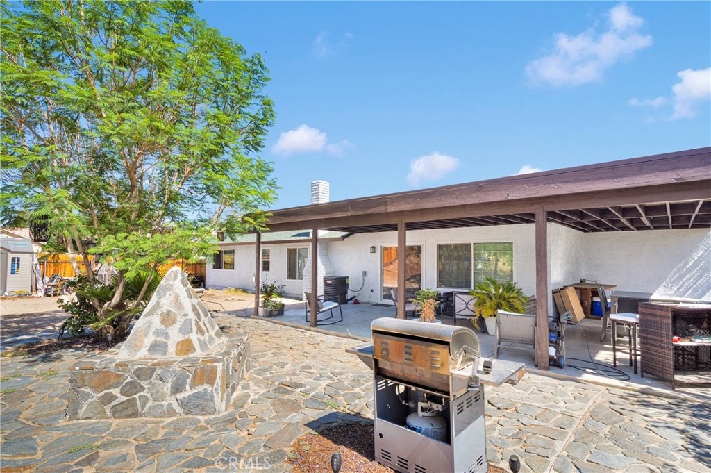 14111 Liberty Way Victorville, CA 92392 - Photo 28 of 39 a view of a patio with dining table and chairs with wooden fence and plants