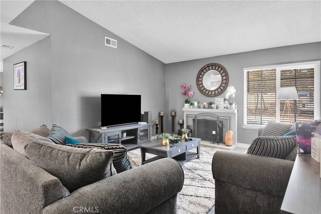 14111 Liberty Way Victorville, CA 92392 - Photo 8 of 39 a living room with furniture a fireplace and a large window