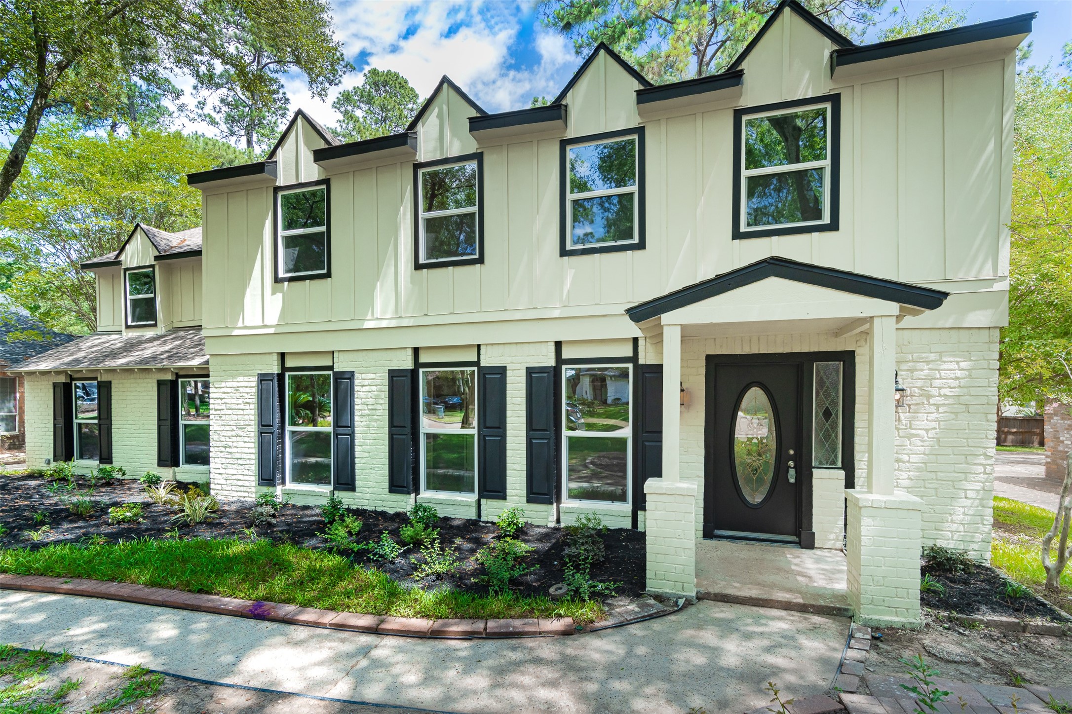 a view of a brick house with many windows and plants