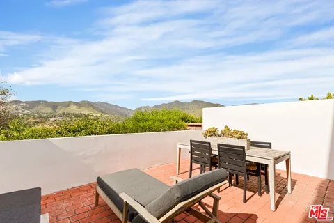 a view of a terrace with a table and chairs