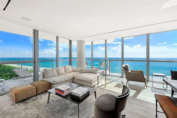 a living room with furniture and floor to ceiling windows