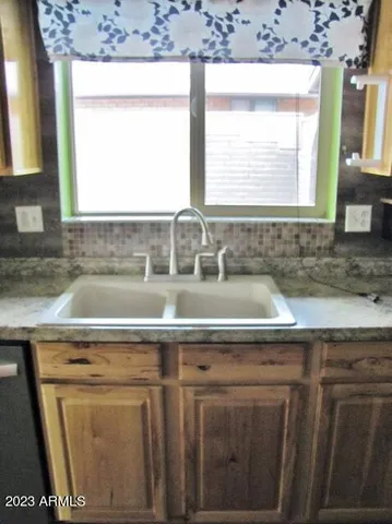 a kitchen with a sink a window and cabinets