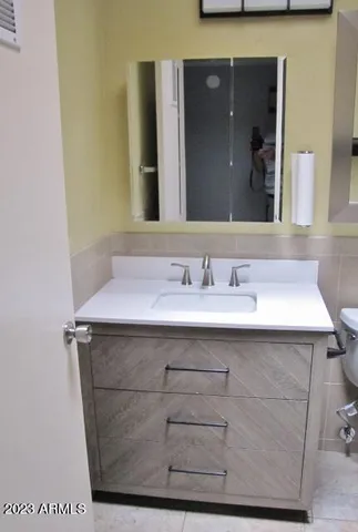a bathroom with a sink vanity and a mirror