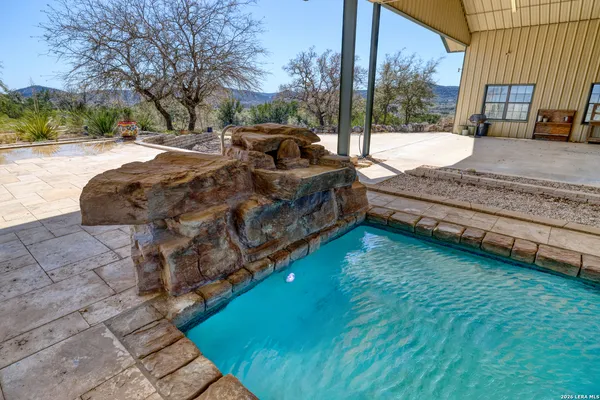 a view of swimming pool with red chairs in patio