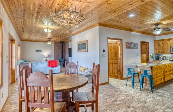 a dining room with stainless steel appliances granite countertop furniture and a window