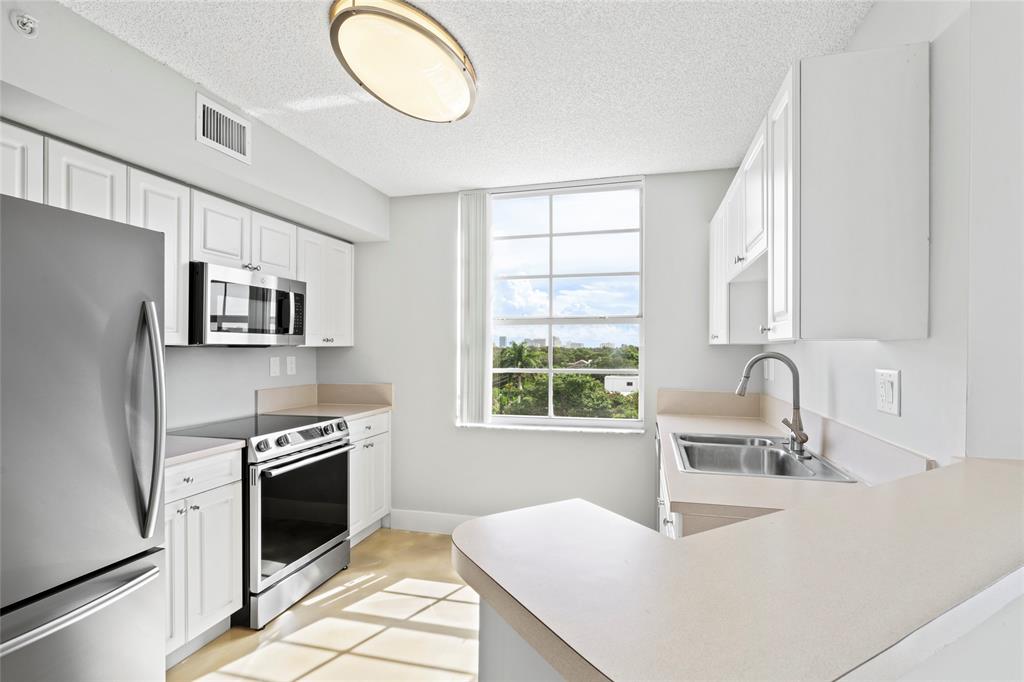 520 Southeast 5th Avenue, Unit 1504 Fort Lauderdale, FL 33301 - Photo 9 of 53 a kitchen with stainless steel appliances a stove sink microwave and window