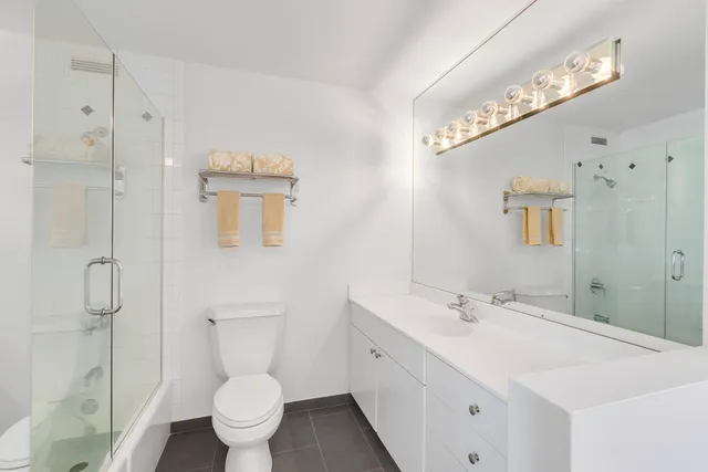 a bathroom with a sink a toilet and shower