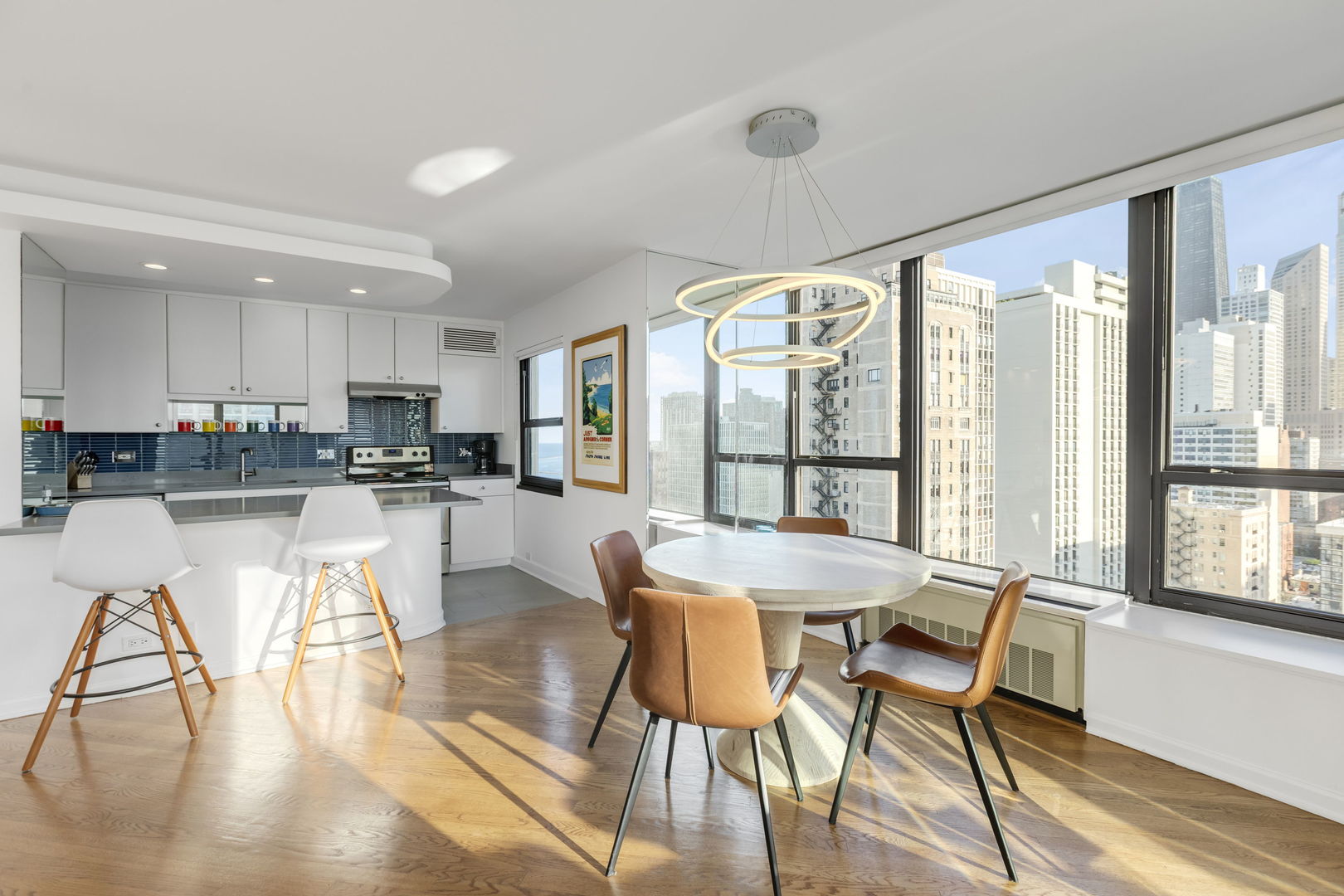 1313 North Ritchie Court, Unit 2401 Chicago, IL 60610 - Photo 9 of 29 a kitchen with stainless steel appliances granite countertop a stove a refrigerator a dining table and chairs with wooden floor