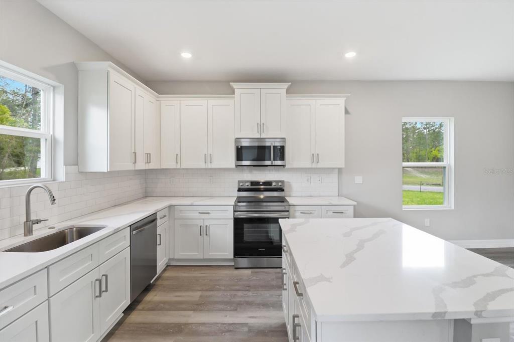 6349 Southwest 134th Loop Ocala, FL 34473 - Photo 13 of 45 a kitchen with a stove a sink and a microwave