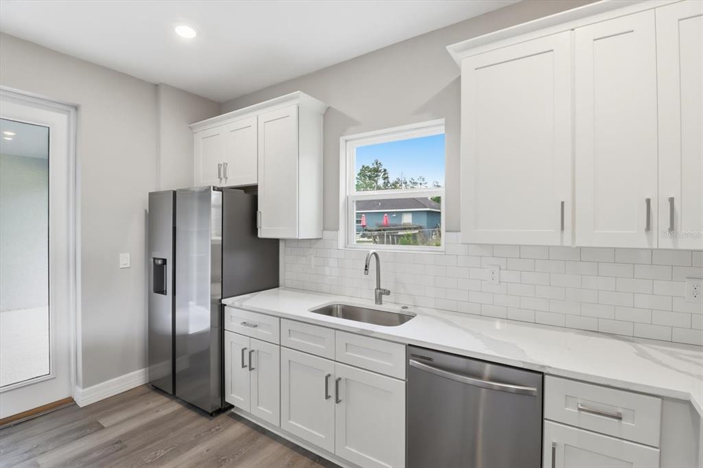 6349 Southwest 134th Loop Ocala, FL 34473 - Photo 14 of 45 a kitchen with white cabinets and stainless steel appliances