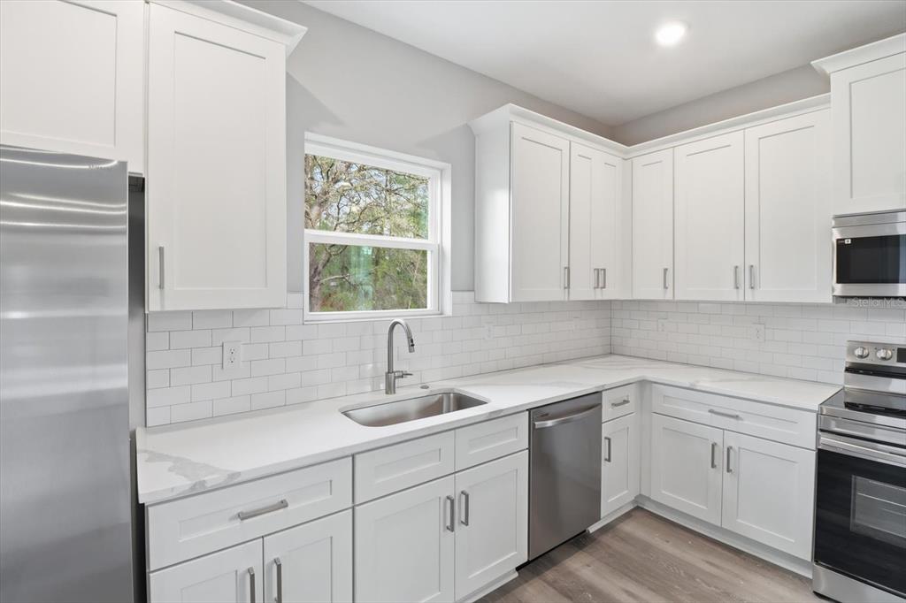 6349 Southwest 134th Loop Ocala, FL 34473 - Photo 15 of 45 a kitchen with white cabinets and sink