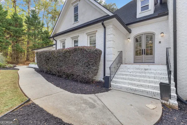 a large white kitchen with granite countertop a stove a sink a window and white cabinets