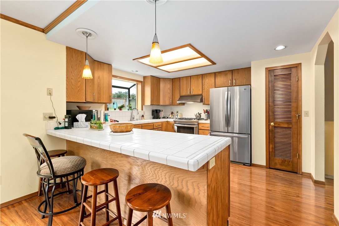 508 Cypress Road Bellingham, WA 98225 - Photo 14 of 40 a kitchen with stainless steel appliances a refrigerator a stove a sink a dining table and chairs