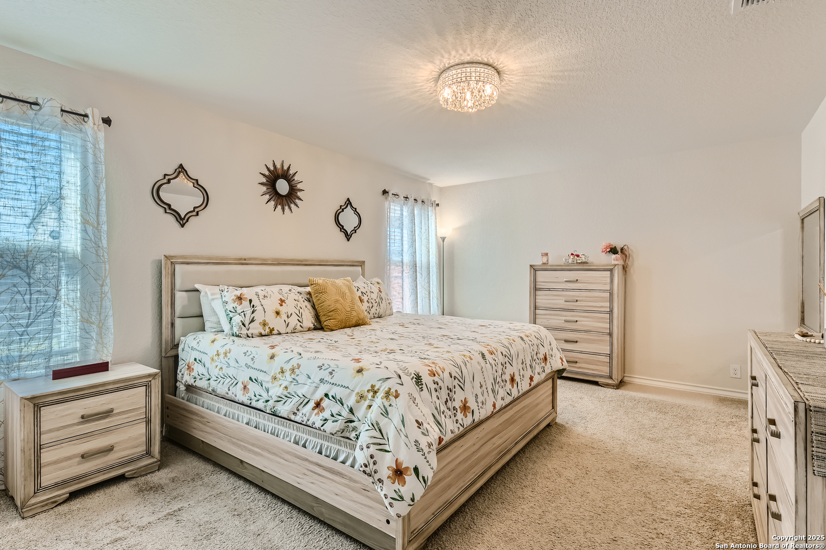 13322 Silky Rye San Antonio, TX 78254 - Photo 14 of 44 a bedroom with a bed and a chandelier