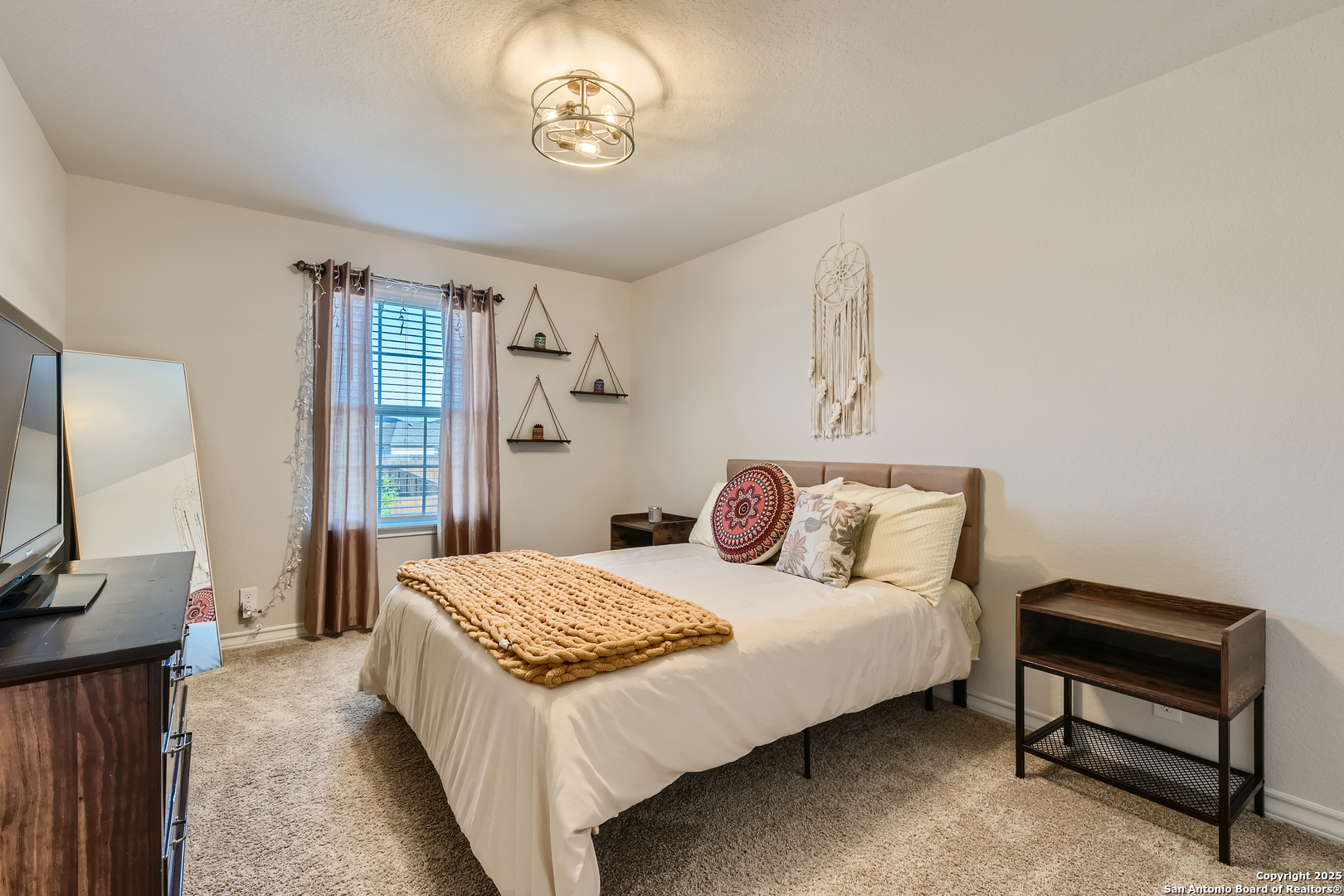 13322 Silky Rye San Antonio, TX 78254 - Photo 20 of 44 a bedroom with a bed and a chandelier