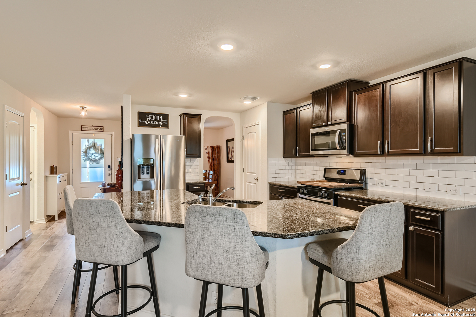 13322 Silky Rye San Antonio, TX 78254 - Photo 8 of 44 a kitchen with stainless steel appliances granite countertop a stove a refrigerator a kitchen island a table and chairs