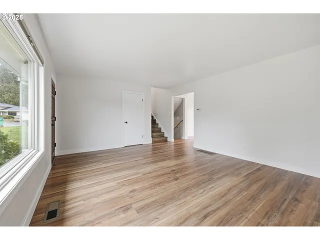 a view of an empty room and wooden floor