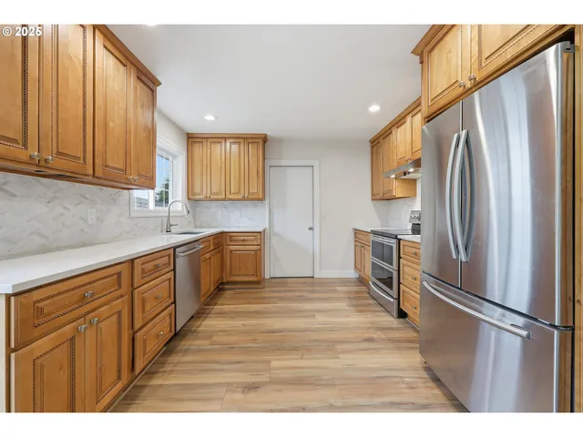 a kitchen with stainless steel appliances granite countertop a refrigerator and a sink