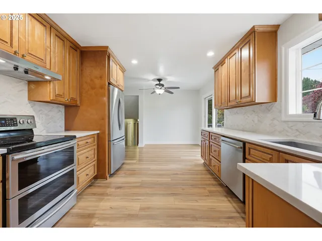 a kitchen with granite countertop a stove a sink and a refrigerator