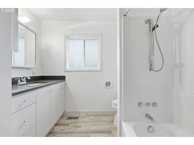 a bathroom with a granite countertop sink a mirror and a bathtub