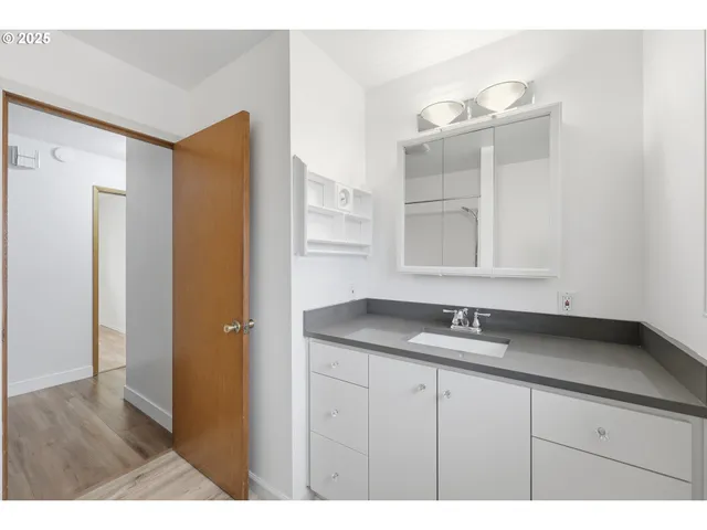 a bathroom with a granite countertop sink and a mirror