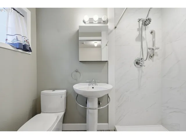 a bathroom with a sink toilet and a mirror