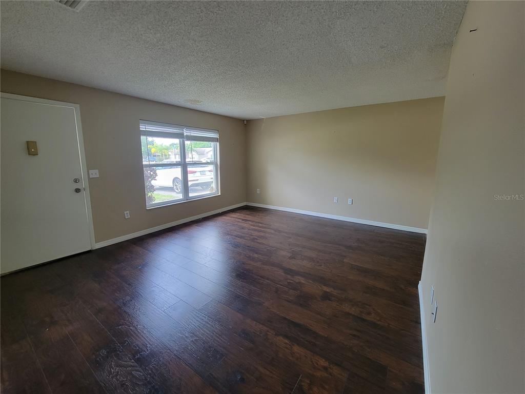 7401 Jenner Avenue New Port Richey, FL 34655 - Photo 3 of 14 an empty room with wooden floor and windows