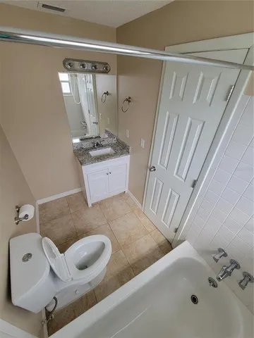 a bathroom with a tub sink and mirror