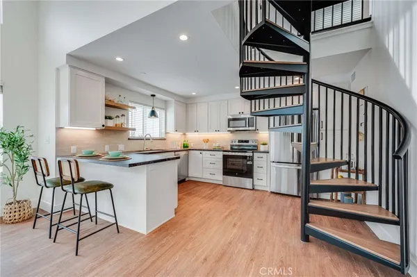 a kitchen with granite countertop a stove a sink and a refrigerator