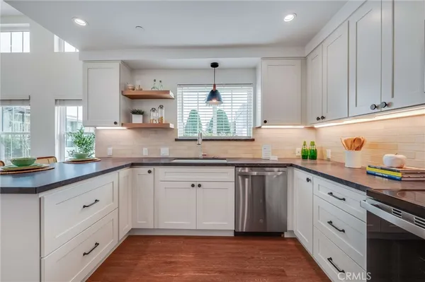 a kitchen with granite countertop white cabinets white appliances and a window