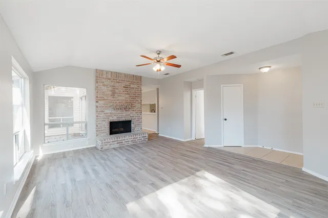 a view of an empty room with a fireplace and a window