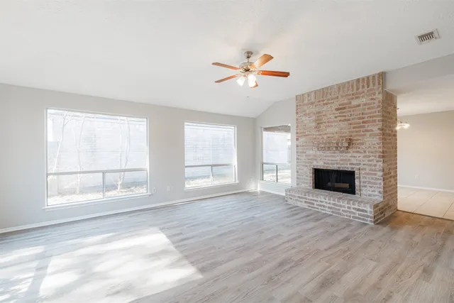 a view of an empty room with a window and fireplace