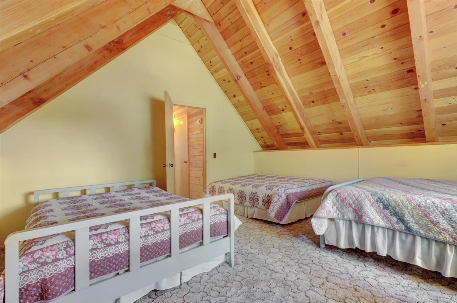 351 Silver Tip Springs Road Strawberry Valley, CA 95981 - Photo 24 of 57 a bedroom with three beds and a chandelier