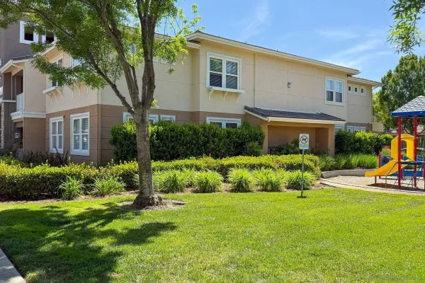 a front view of a house with a yard and plants