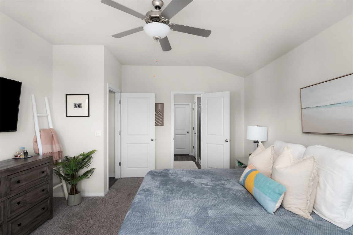 6511 Rounded Pebble Lane Buda, TX 78610 - Photo 13 of 25 Bedroom with carpet, lofted ceiling, and ceiling fan
