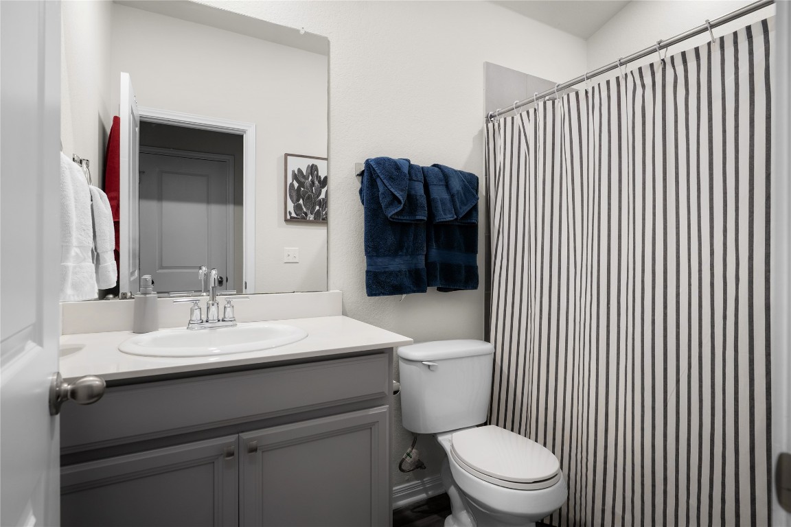 6511 Rounded Pebble Lane Buda, TX 78610 - Photo 19 of 25 Bathroom with curtained shower and vanity