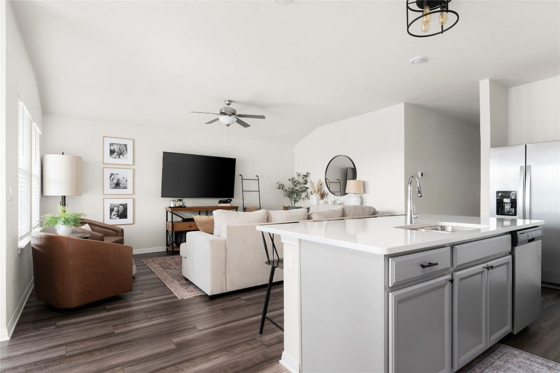 6511 Rounded Pebble Lane Buda, TX 78610 - Photo 25 of 25 Kitchen with a breakfast bar, a center island with sink, open floor plan, dark wood-style floors, and a ceiling fan