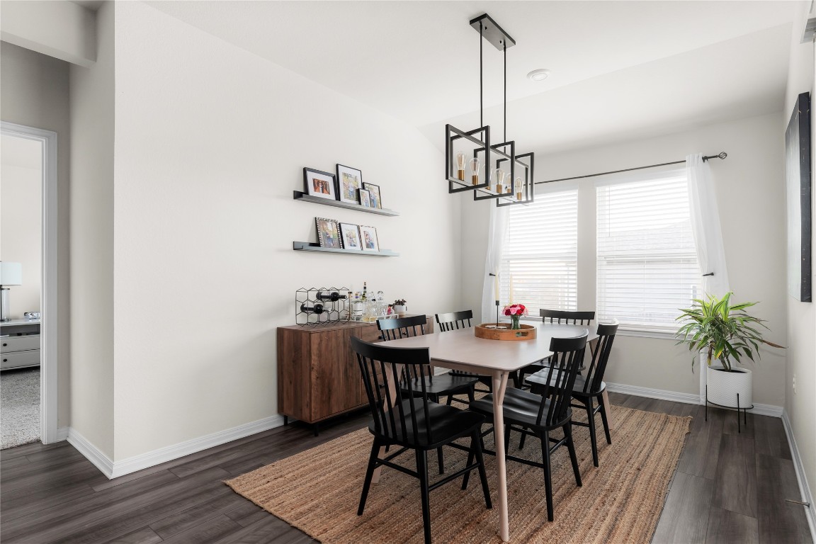 6511 Rounded Pebble Lane Buda, TX 78610 - Photo 6 of 25 Dining area featuring dark wood-style flooring and a chandelier